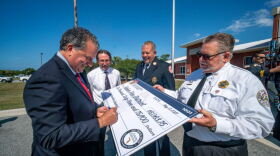Florida CFO signs check to Panhandle Firefighters. Funding will be used for protective equipment.