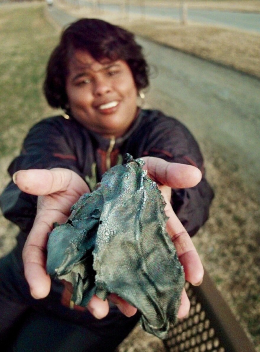 Lottie Williams holds a piece of a Delta II rocket that fell from the sky and hit her in the back while she was walking on a trail in Tulsa, Okla., in 1997.