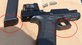 A black handgun with the magazine removed.