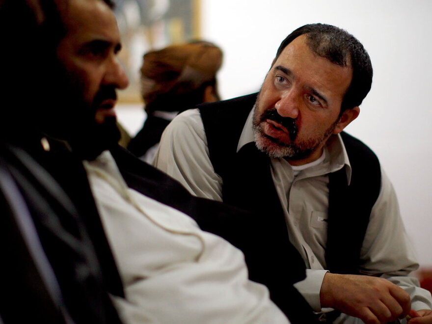 Ahmed Wali Karzai (right) confers with a fellow Afghan at a recent conference in Kandahar.
