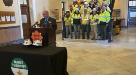 Acting DOT Commissioner Dale Doughty speaks at a press conference at the State House with highway workers behind him. The construction helmets of Dwayne Campbell and James Brown, the two state transportation workers killed Jan. 13, 2026, sit on the table before the podium. A moment of silence was held in their honor.