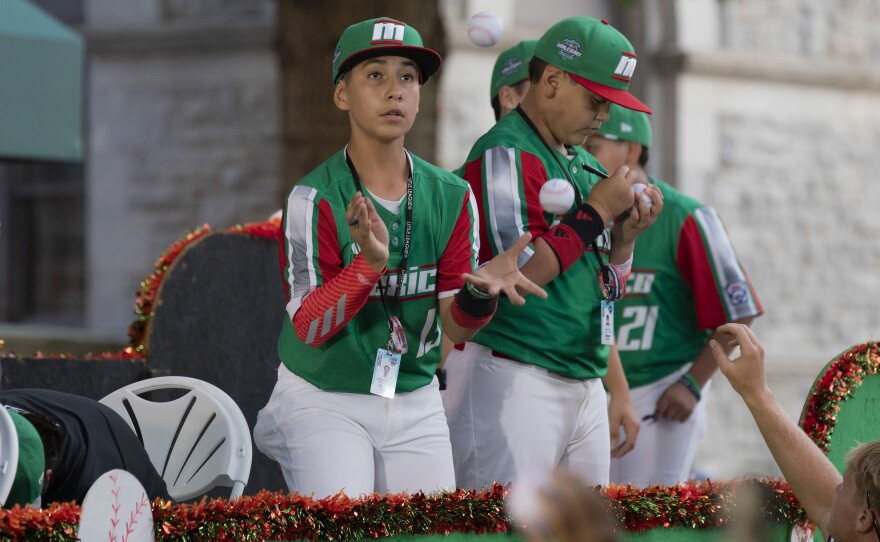 Oscar Mateo Montañez, a member of the team from Mexico, catches a ball to autograph during the Little League World Series parade.