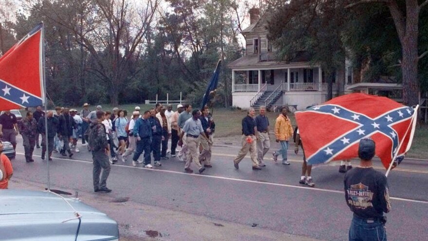 The "Get In Step" marchers pass by a small group of Confederate Flag supporters Tuesday, April 4, 2000, near Wells, S.C., on their way to Orangeburg on the third day of the march to Columbia to have the flag taken down from the Statehouse.