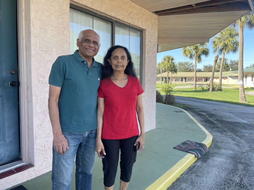 Bharti Patel, 65, and her husband Vinod, 72, stand outside the Safari Inn on US 27 onlooking as Duke Energy linemen restore power to their community in Sebring.