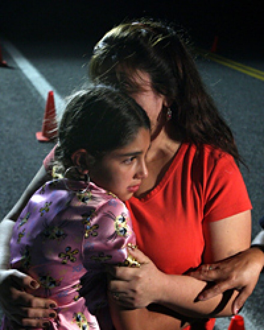 Maria Lerma hugs her daughter, Adilene, as they wait to hear news about her husband, Natalio, who was in the Crandall Canyon coal mine when it collapsed Thursday. Lerma reportedly escaped the mine without injury.
