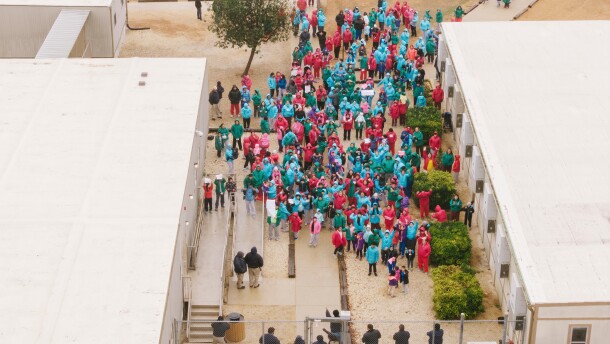 Detainees held at the South Texas Family Residential Center wave signs during a demonstration in Dilley, Texas, Saturday, Jan. 24, 2026.