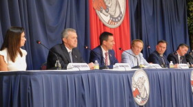 Candidatos Republicanos estan sentandos en una mesa durante el primer debate del 2022. 