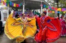 Two dancers hold colorful yellow and red skirts, twirling them through the air.