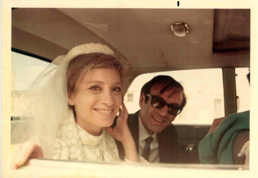 Elie and Marion Wiesel in a wedding photo. The couple are inside the backseat of a car and smile at the camera.