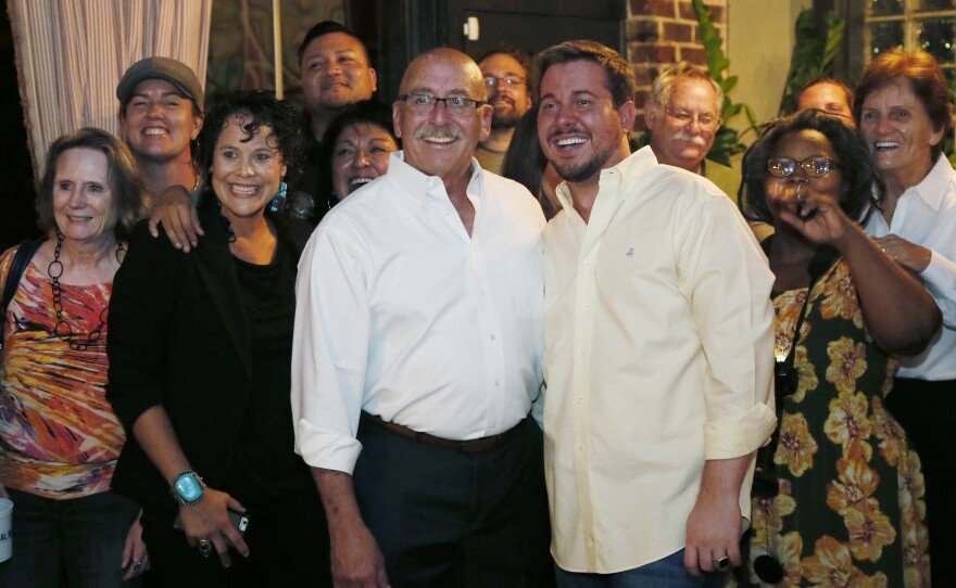 Former state Sen. Al McAffrey (left center) poses with his partner, David Stinson, and other supporters as they take a group photo during his August 23, 2016 night watch party for run-off election in the Democratic race for the 5th Congressional District.
