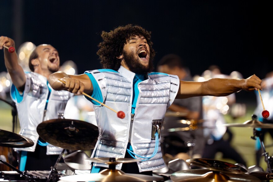 The Boston Crusaders marimba player Xian Lewis, 21, of Bedford, New Jersey, reacts while performing the corps’ show “BOOM” at Belleville West High School on Tuesday, July 22, 2025, in Belleville.
