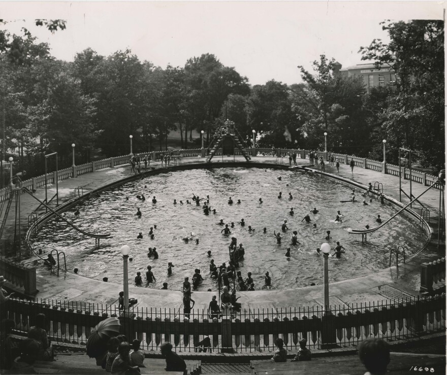 Black and white photo of the Moores Park Pool from the stands, looking down into the basin full of people