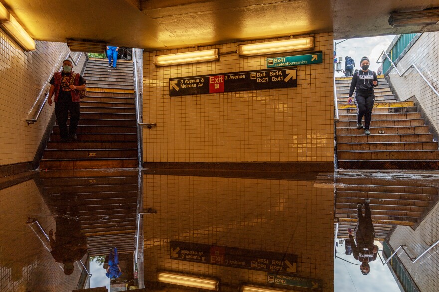 Commuters head into New York's Third Avenue-149th Street subway station on Thursday. Heavy rain from remnants of Hurricane Ida flooded much of the city's subway system. Authorities issued a travel ban and warned residents to avoid stations.