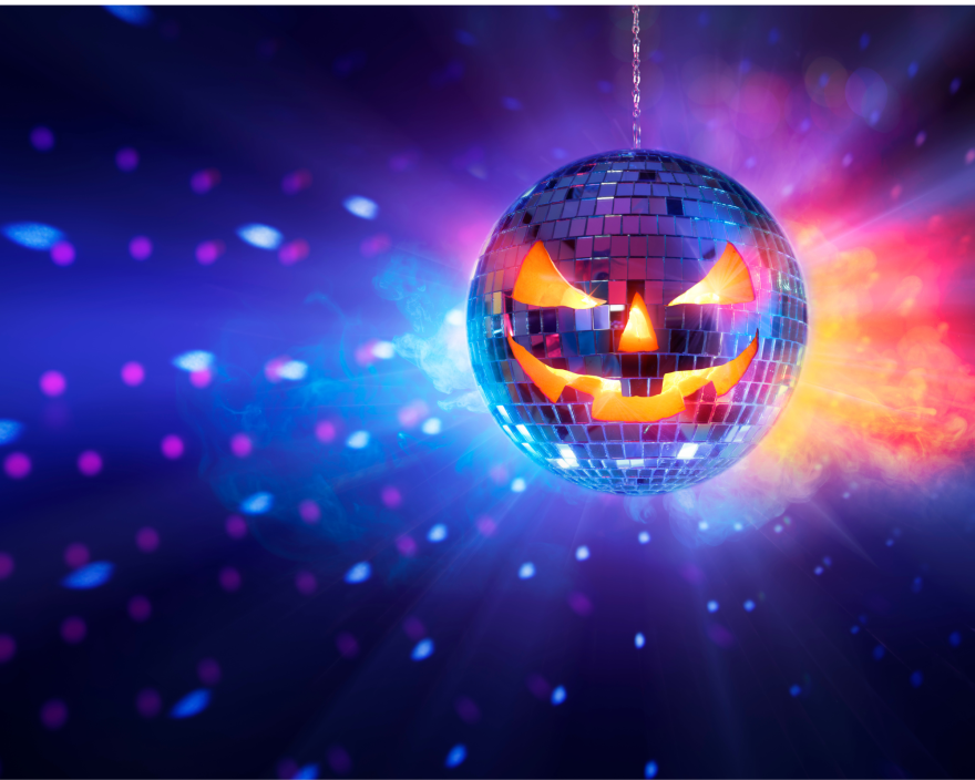 A mirrored disco ball with a glowing jack-o'-lantern face hangs against a colorful background of blue, purple, pink and orange lights.