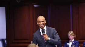 African American man smiling holding microphone 