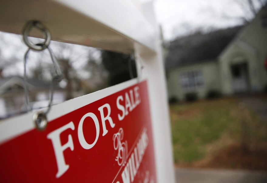 This Jan. 26, 2016 file photo shows a "For Sale" sign hanging in front of an existing home in Atlanta.  Short of savings and burdened by debt, America's millennials are struggling to afford their first homes in the face of sharply higher prices in many of the most desirable cities. Surveys show that most Americans under 35 lack adequate savings for down payments. The result is that many will likely be forced to delay home ownership and to absorb significant debt loads if they do eventually buy. (John Bazemore, File/AP)