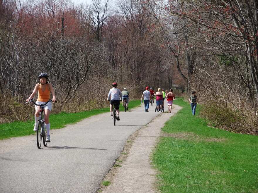 a paved trail with lots of people on bikes or walking