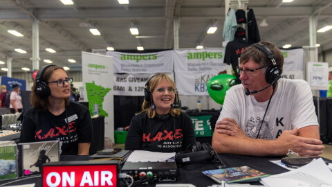 KAXE Morning Show producer Jennifer Barr, left, Director of Content and Public Affairs Heidi Holtan, and volunteer Mark Klabunde chat during an interview broadcast live Aug. 28, 2026, from the Minnesota State Fair.