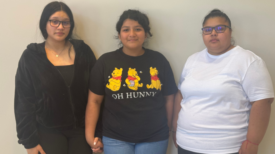 Daughters Ashly Benítez Gonzalez and Nercely Gonzalez Ortiz hold hands next to Idalia Lopez Urbina.
