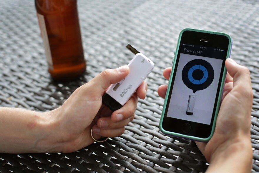 The BACTrack Vio keychain breathalyzer and app on the iPhone at NPR headquarters in Washington, D.C. A public health researcher says tools like this could help people make better decisions about alcohol use.