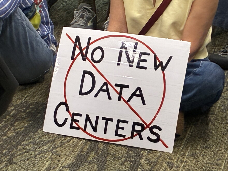 An opponent of data centers in the Roanoke Valley holds a sign during a meeting of the Western Virginia Regional Industrial Facility Authority.