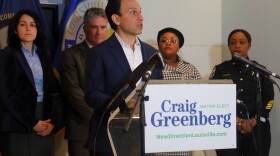 Louisville Mayor-elect Craig Greenberg stands at a podium in front of his senior leadership team