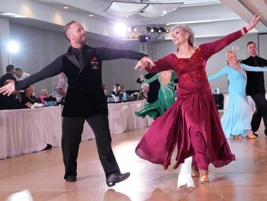 People ballroom dance while being judged