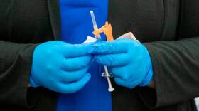 A nurse holds a needle with the Pfizer COVID-19 vaccine at HSHS St. Elizabeth’s Hospital in O’Fallon, Illinois.