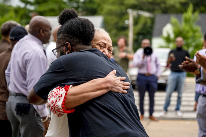 First grade teacher Ella Barnes hugs former student Corey Nickson who came out to welcome students to Rawson Elementary School on the first day of the new school year. The students and families of Rawson Elementary School in Hartford are greeted with enthusiasm by members of Calling All Brothers.