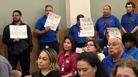 VIA worker's union members hold signs showing opposition to the free fare policy