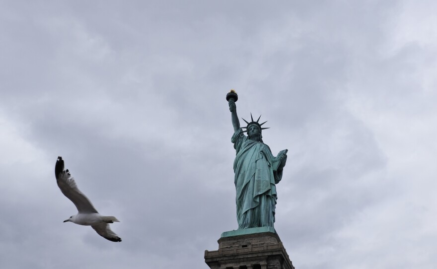 A seagull flies past the Statue of Liberty on Liberty Island on April 8, 2016. A smaller replica of Lady Liberty will soon be erected across from the original on Ellis Island.