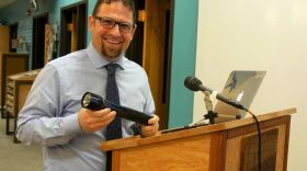 Petersburg Middle and High School Principal Rick Dormer shows off the school’s new Passive Alcohol Sensor at the school board meeting, April 10, 2018. (Photo by Angela Denning/KFSK)