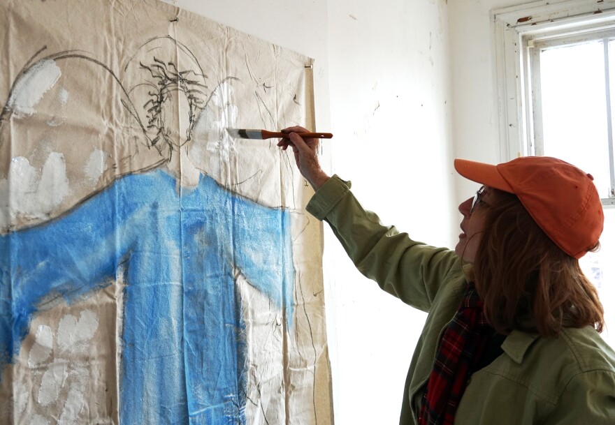 Jerre Wike-Picker of Grace Church paints a "protecting angel" on a sheet of canvas on February 2, 2019. The church is partnering with nonprofit LOVEtheLOU to restore a vacant home in the city's Vandeventer neighborhood.