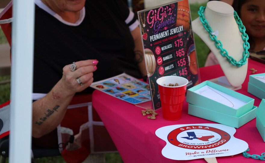 Woman playing Loteria while manning her vendor booth at the 5th Annual Hispanic Heritage Celebration at Riverside Park. Photo by Allison Diaz.