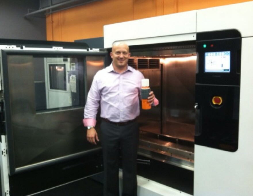 Matt Hlavin stands in front of a rapid prototyping and manufacturing machine. These can produce small batches of plastic products quickly and cheaply. This is the future, he says.