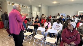 Image, woman in pink top teaching group relaxation techniques to reduce stress.