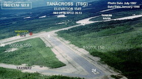 An 1980s image of the Tanacross airport alerts pilots to cracks in the asphalt of one of the runways and vegetation growing up through the tarmac.