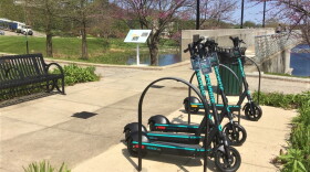 VeoRide scooters lined up near a bike rack in Bloomington.