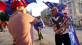 A supporter of President-elect Joe Biden, left, exchanges viewpoints with supporters of President Donald Trump, right, outside the Pennsylvania State Capitol, Saturday, Nov. 7, 2020, in Harrisburg, Pa., after Biden defeated Trump to become 46th president of the United States. (AP Photo/Julio Cortez)