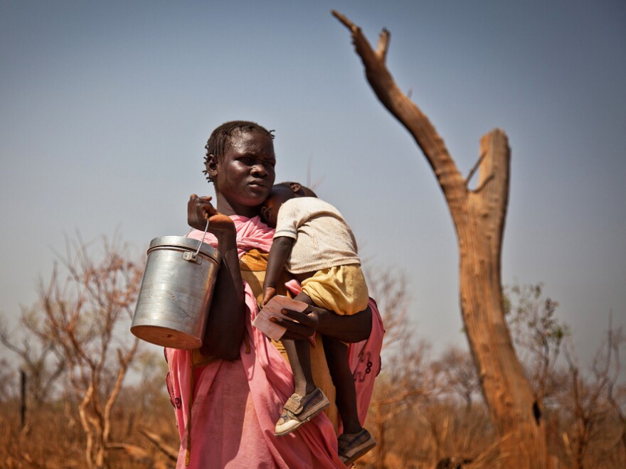 A displaced woman and her child from the Nuba Mountains in Sudan wait outside the Yida refugee camp registration center in Yida, South Sudan April 26. Thousands of people from the Nuba Mountains in South Kordofan, Sudan have fled to Yida to escape recent fighting and airstrikes by Sudan's Armed Forces.