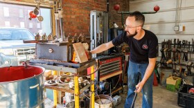 Bloomington bladesmith and knife sharpener Taylor Mathews with his forge in Edge of Normal Workshop.