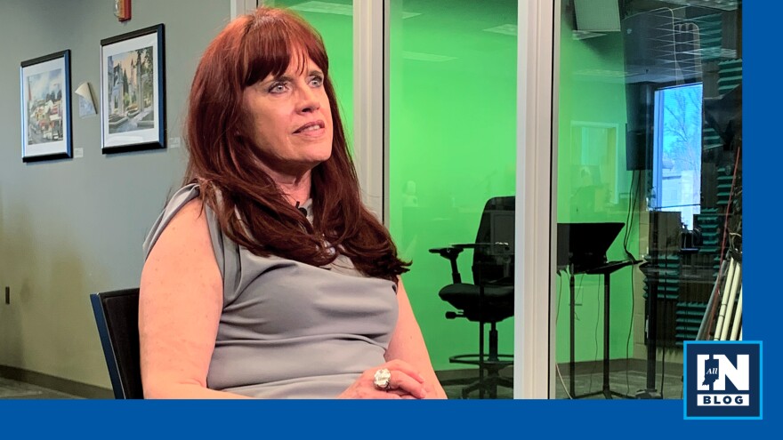  Pamela Boswell-Dike in the news room at Indiana Public Media, speaking during an interview, with a glass-walled recording room and equipment visible behind her; image used for an All IN blog article.