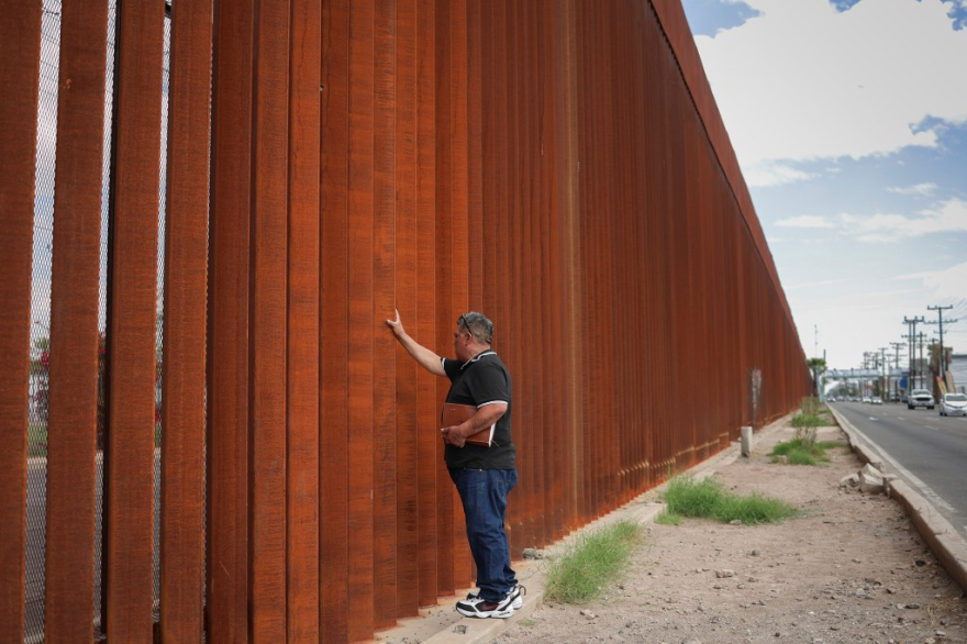 Luis Arreguin touches the border wall in Mexicali, Baja California, Mexico, on Oct. 21, 2026. Arreguin was deported from the U.S. on Oct. 15, 2026. Photo by Daniel Resendiz for CalMatters