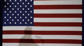 President Trump's shadow is shown on an American flag. (Chuck Burton/AP)