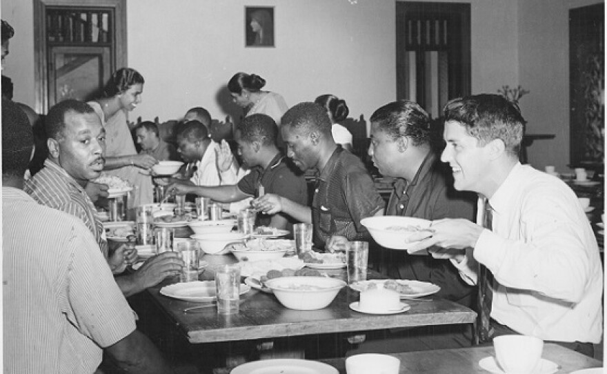 photo of people seated at a long table eating a meal