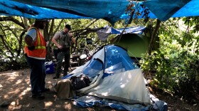 A homeless camp outside Jacob Maurie Park is visited by clean-up crews.