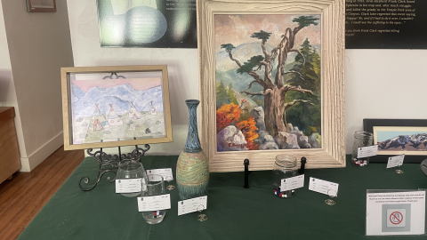 A painting of a tree, a drawing of Native American tent dwellings, and a narrow-necked vase.