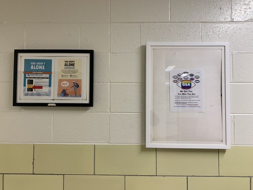 A poster for the South Side High School's Gay Straight Alliance hangs outside of the school library where a board committee debates pronoun usage.