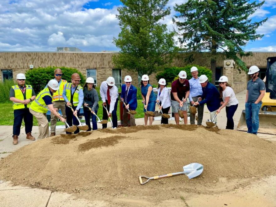Group of people with shovels digging into dirt.