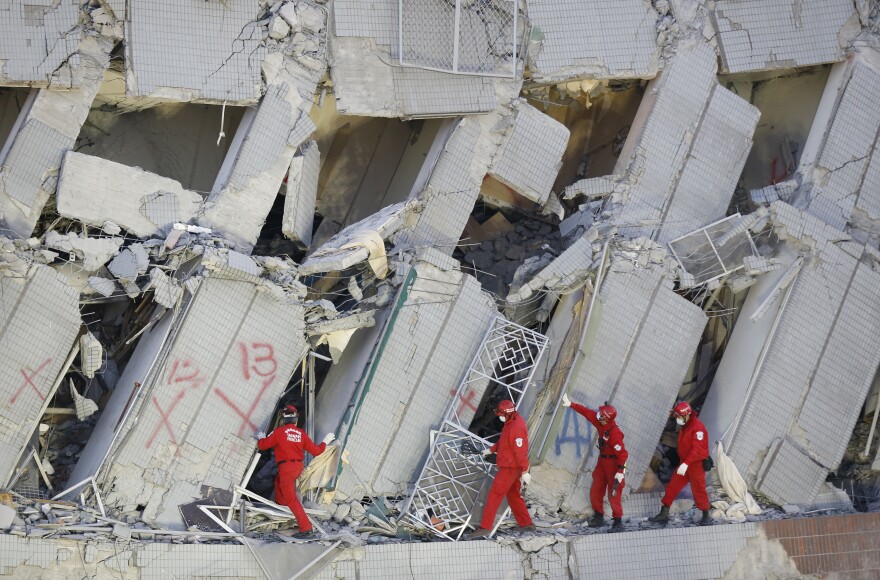 Emergency rescuers search for missing in a collapsed building on Sunday.